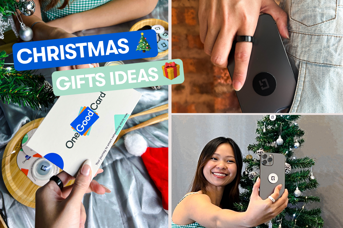 A lady taking a selfie with a Christmas tree with her phone. A lady passing a One Good Card as a gift to another person.