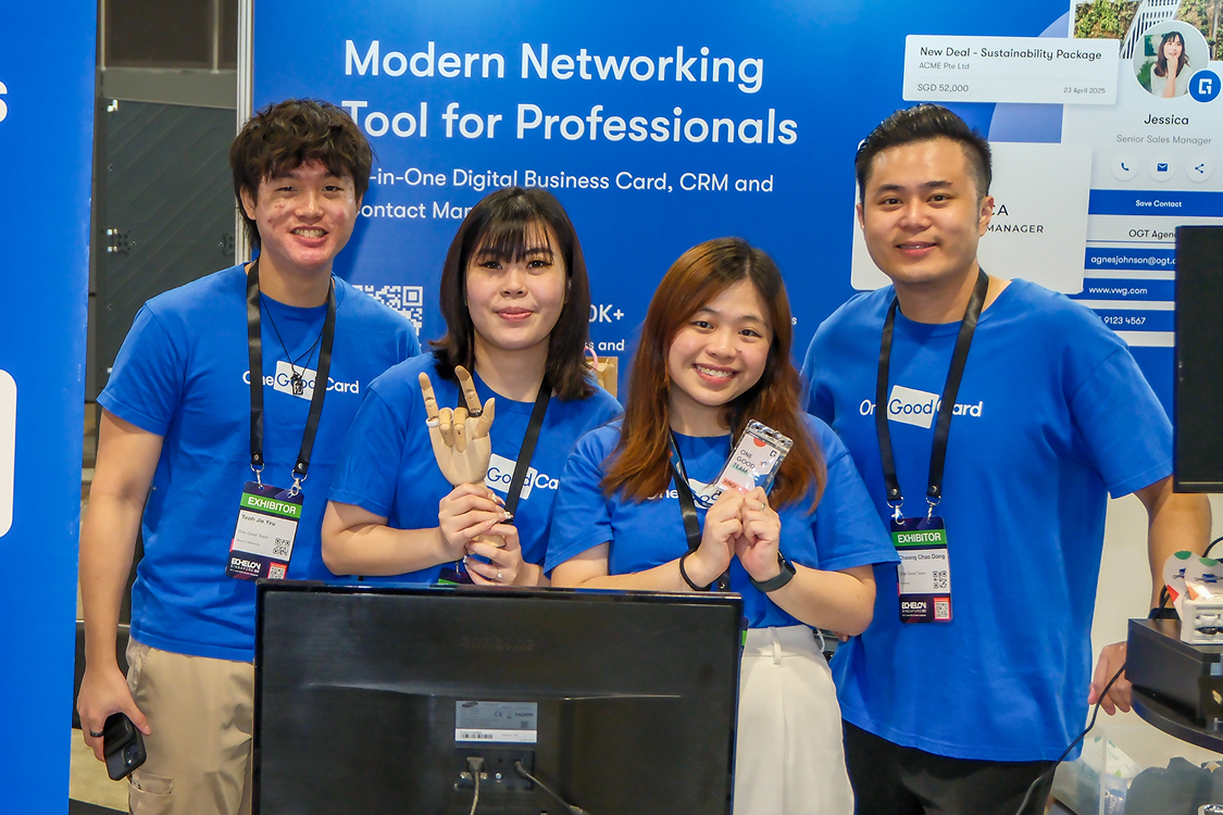 Four One Good Card team members at their exhibition booth in matching blue tees