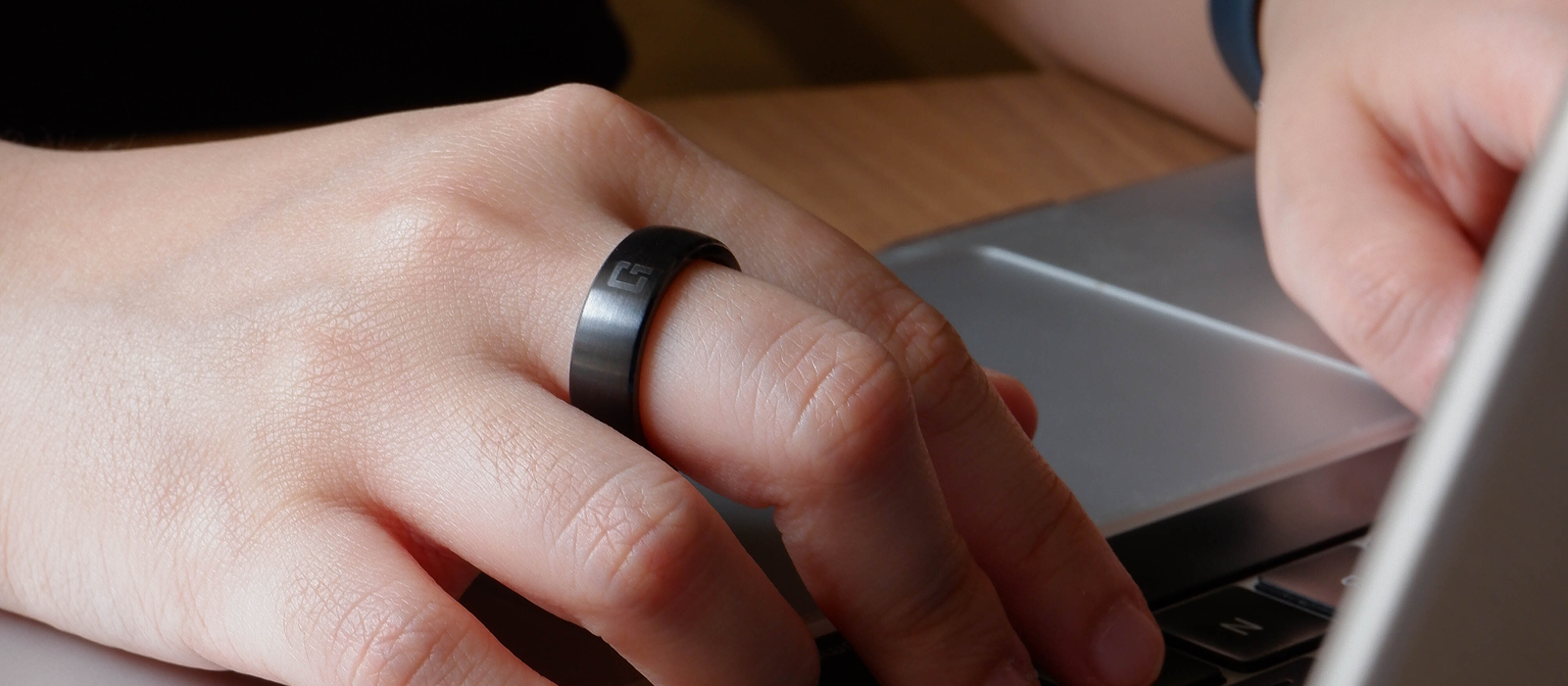 One Good Ring smart NFC ring worn while working on a laptop for contactless profile sharing