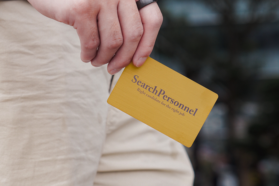 Gold metal NFC business card being removed from a pocket as a luxury corporate gift