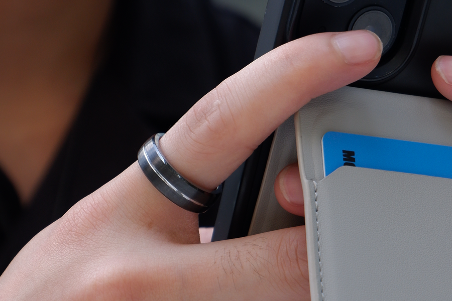 Person tapping a smartphone against an NFC card holder to share a digital business card